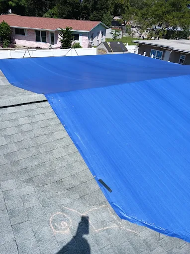 Blue tarp installed over a shingle roof